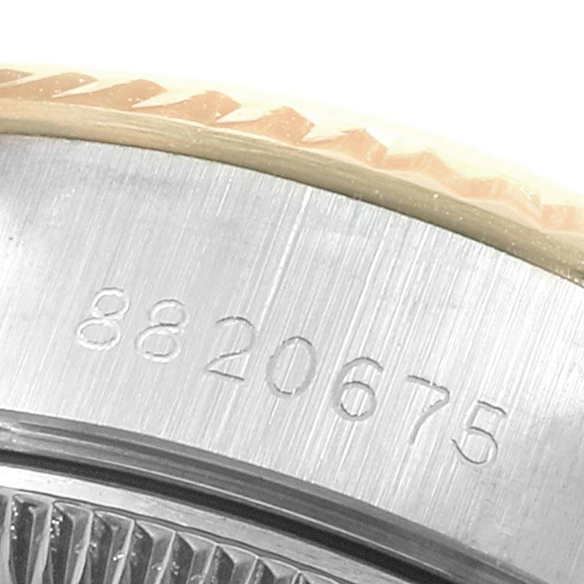 This close-up image of the Rolex Datejust 69173 Women's Stainless Steel Black Dial 69173 Women's Stainless Steel Black Dial watch shows the serial number engraving and a portion of the fluted bezel.