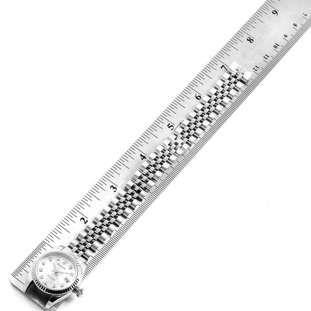 The Rolex Datejust 179174 Women's Stainless Steel Silver Dial 179174 Women's Stainless Steel Silver Dial watch is shown from above, highlighting its face and metal bracelet, placed next to a ruler for measurement.