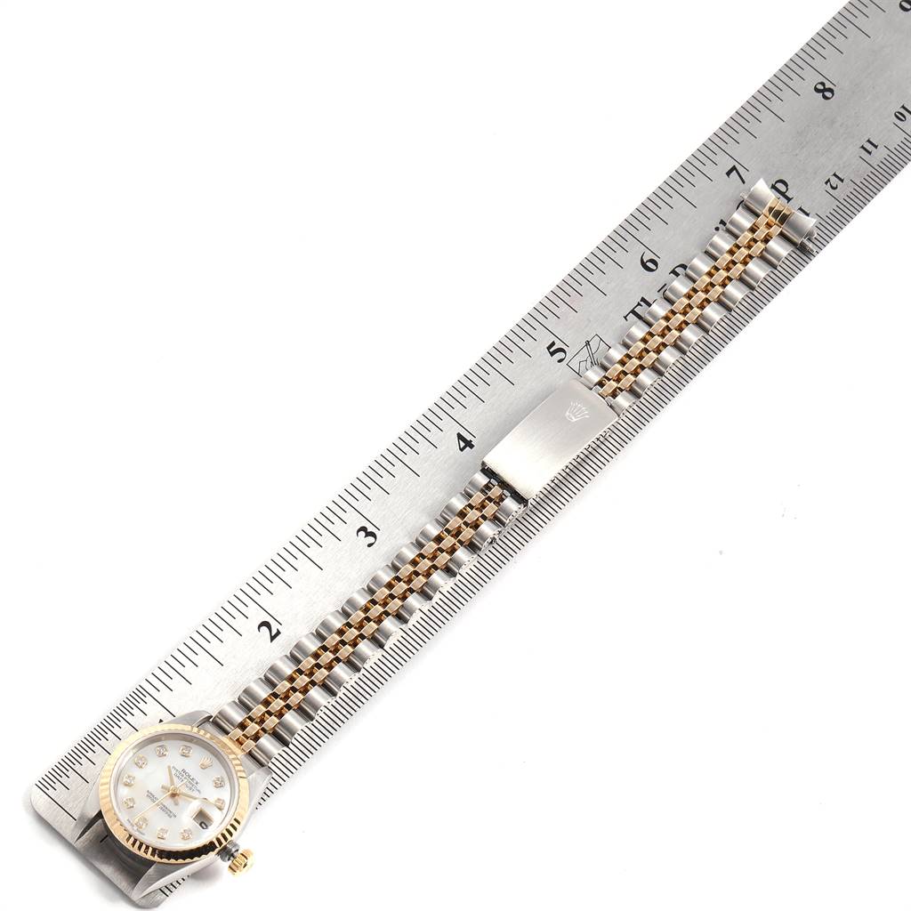 The Rolex Datejust 69173 Women's Stainless Steel Mother of Pearl Dial 69173 Women's Stainless Steel Mother of Pearl Dial watch is shown laid flat with its face, band, and clasp aligned next to a ruler for measurement.