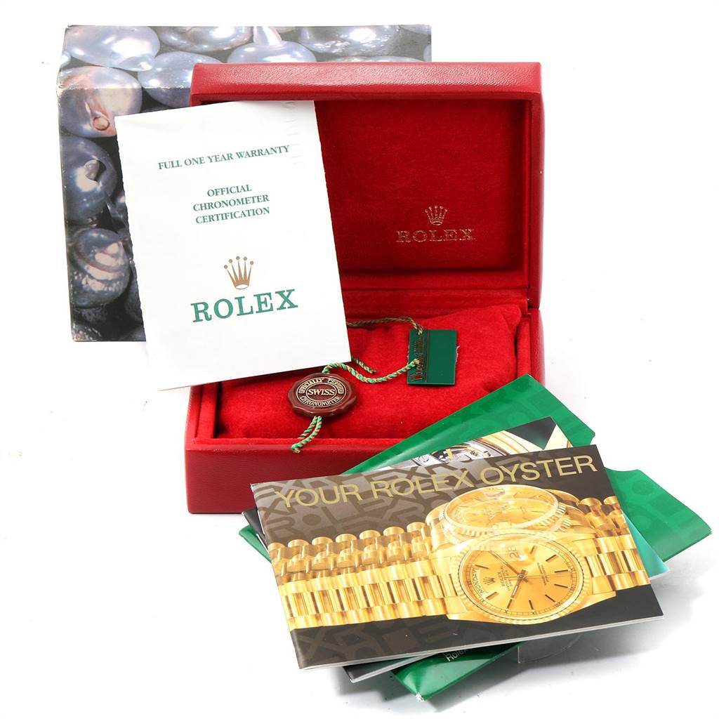 The image shows a red Rolex box for the Datejust model, warranty card, chronometer certification, and instruction booklets.