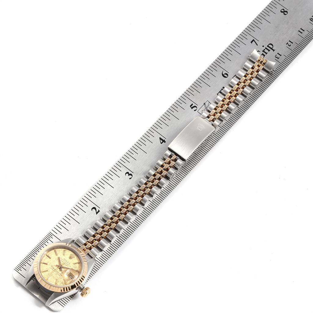 The Rolex Datejust 69173 Women's Stainless Steel Champagne Dial 69173 Women's Stainless Steel Champagne Dial watch is shown from a top-down angle, aligned with a ruler for measurement, displaying its face, crown, and bracelet.