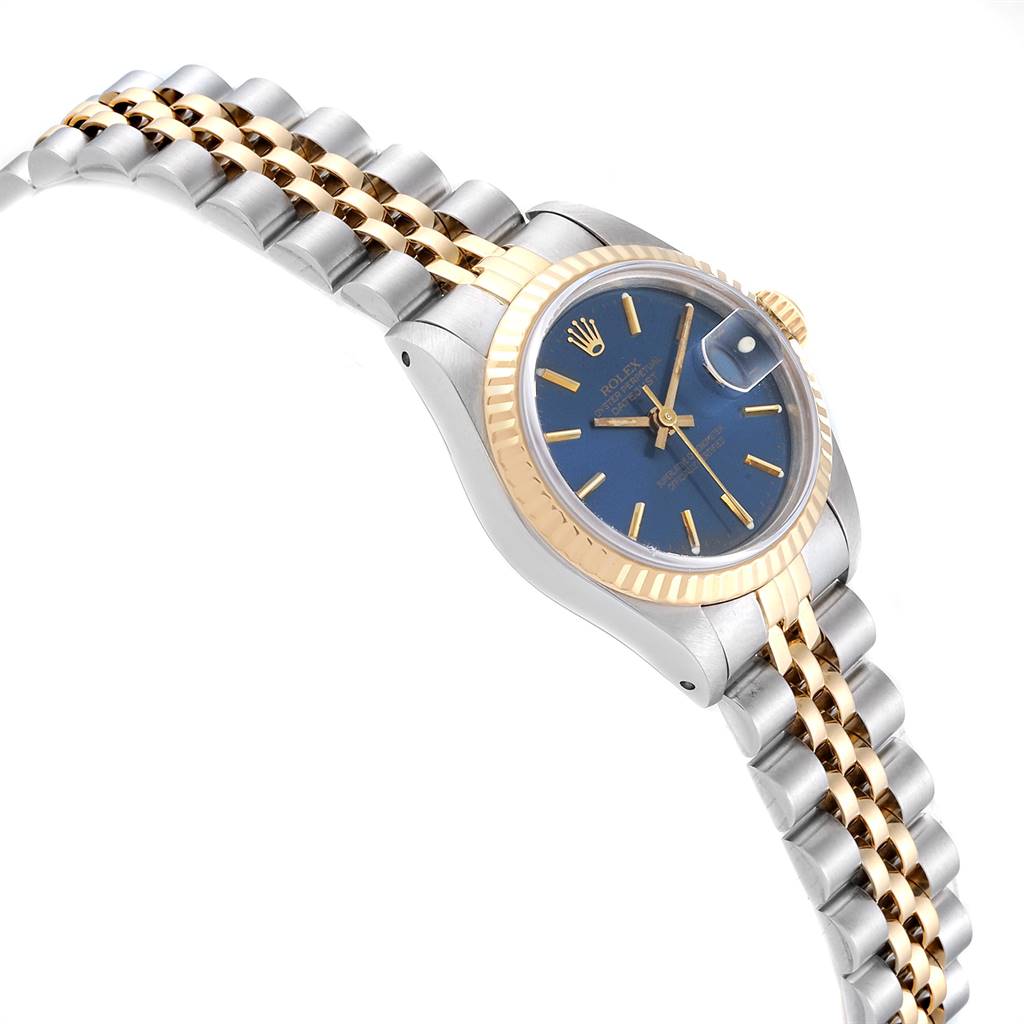 The image shows a Datejust Rolex watch from an angled top-down perspective, highlighting the blue dial, fluted bezel, and two-tone bracelet.