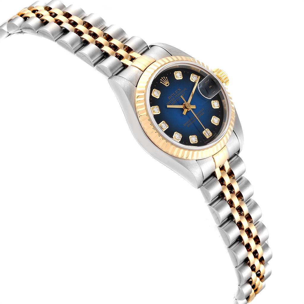This image shows a Rolex Datejust 79173 Women
s Steel and Gold (two tone) Blue Dial 79173 Women
s Steel and Gold (two tone) Blue Dial watch angled to display part of its bracelet, the bezel, and the dial.