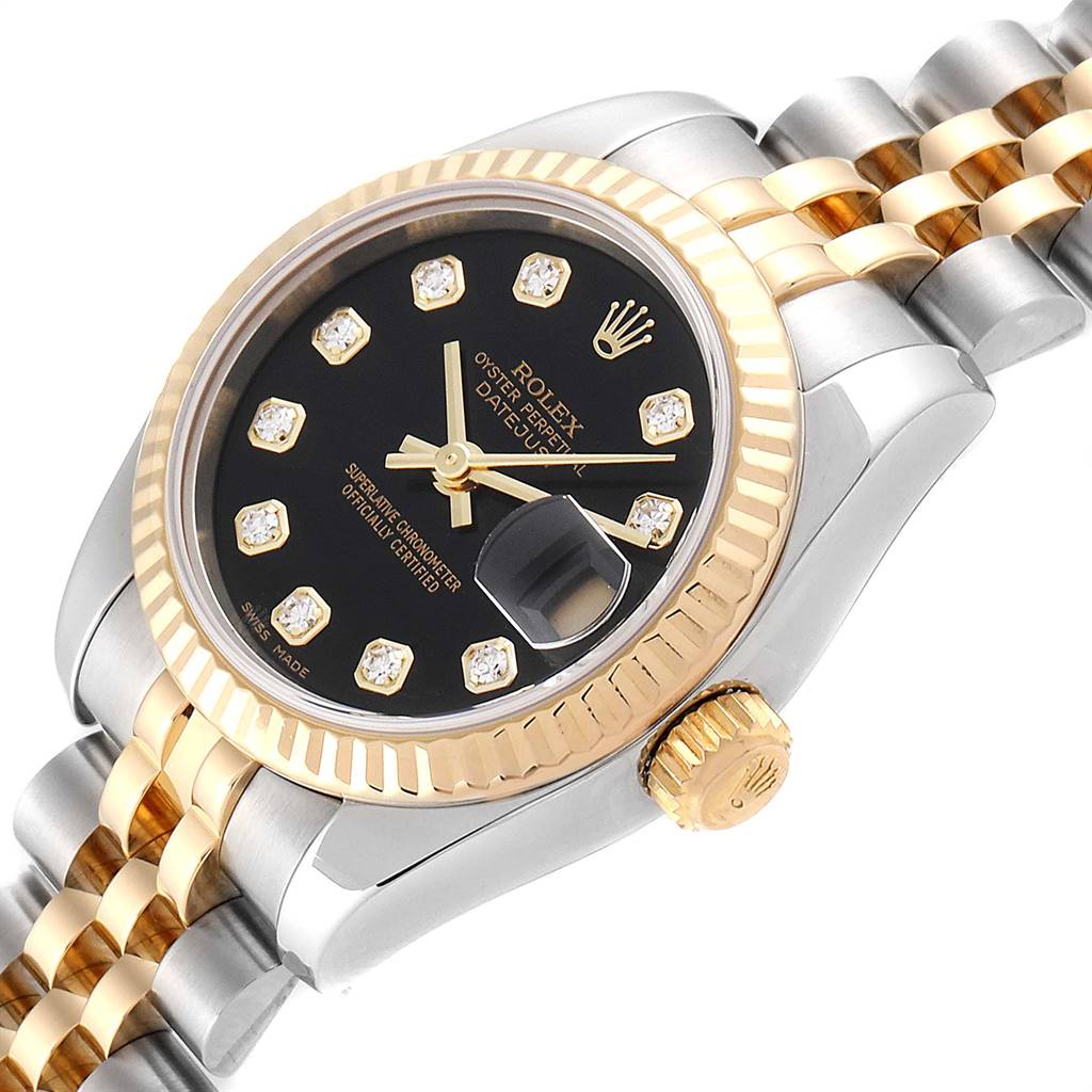 The image shows a Rolex Datejust 179173 Women
s Steel and Gold (two tone) Black Dial 179173 Women
s Steel and Gold (two tone) Black Dial watch from a side angle, highlighting its black dial, gold bezel, and two-tone bracelet.