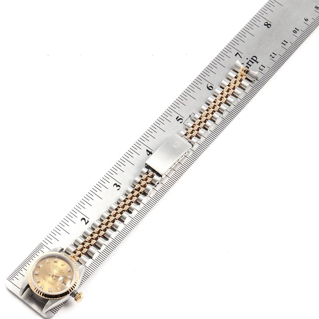 The image shows a top view of a Rolex Datejust 69173 Women's Stainless Steel Champagne Dial 69173 Women's Stainless Steel Champagne Dial watch placed against a ruler, highlighting the watch face and bracelet.