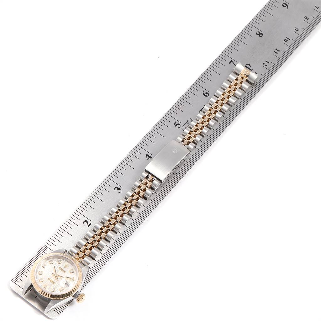 The Rolex Datejust 79173 Women's Stainless Steel Silver Dial 79173 Women's Stainless Steel Silver Dial watch is shown from an overhead angle, displaying the face, bracelet, and clasp, alongside a ruler for measurement.