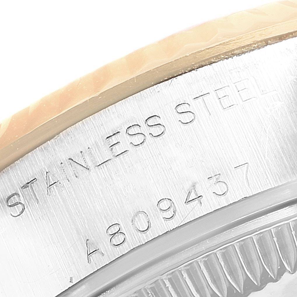 The image shows a close-up of the side of a Rolex Datejust 79173 Women
s Steel and Gold (two tone) Champagne Dial 79173 Women
s Steel and Gold (two tone) Champagne Dial watch, highlighting the stainless steel engraving and serial number.