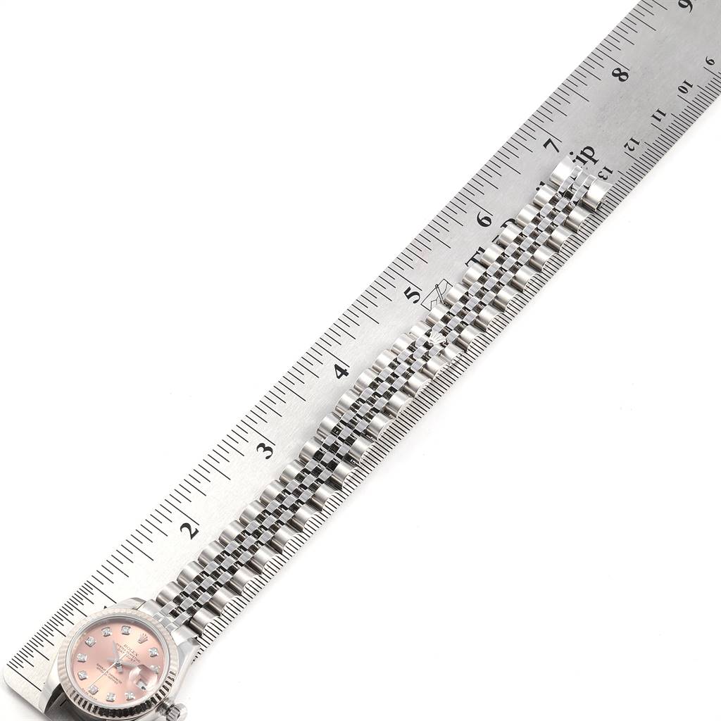 This image shows a Rolex Datejust 179174 Women's Stainless Steel Pink Dial 179174 Women's Stainless Steel Pink Dial watch face and bracelet, placed alongside a ruler for measurement.