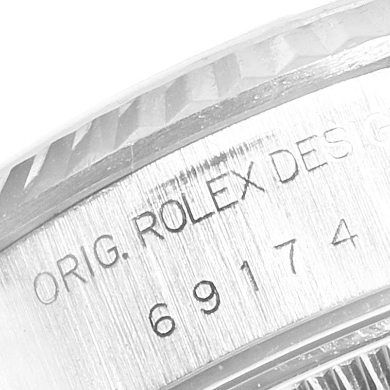 The image shows a close-up of the case back inscriptions and a portion of the fluted bezel of a Rolex Datejust 69174 Women's Stainless Steel White Dial 69174 Women's Stainless Steel White Dial watch.