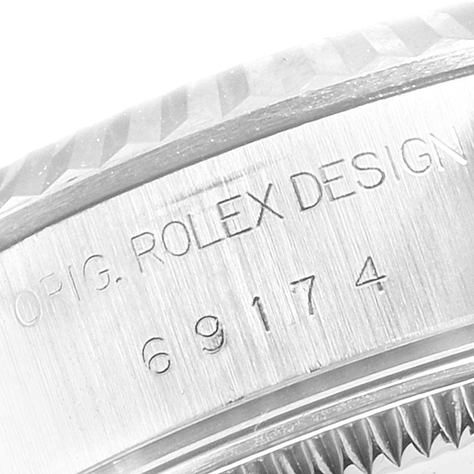 The image shows a close-up of the engraved side of a Rolex Design Datejust model watch.