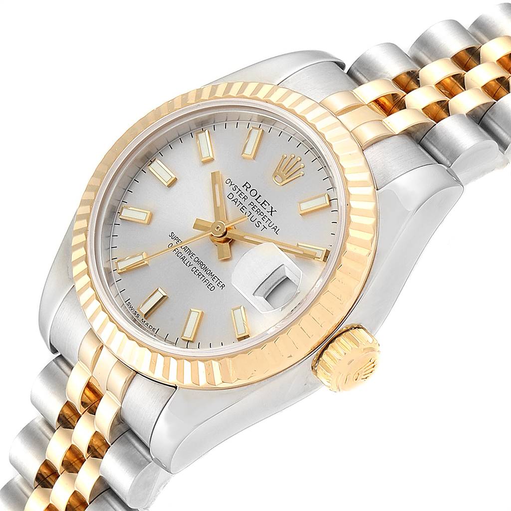This image shows a close-up of a Rolex Datejust 179173 Women's Steel and Gold (two tone) Silver Dial 179173 Women's Steel and Gold (two tone) Silver Dial watch at an angle highlighting its face, bezel, crown, and portion of the bracelet.