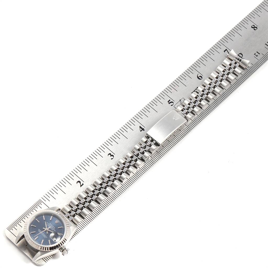 The Rolex Datejust 69174 Women's Stainless Steel Blue Dial 69174 Women's Stainless Steel Blue Dial watch is shown fully extended with a ruler for measurement, highlighting the face, bracelet, and clasp.
