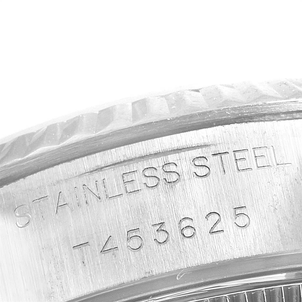 This close-up image shows the stainless steel case back and part of the fluted bezel of a Rolex Datejust 69174 Women's Stainless Steel Blue Dial 69174 Women's Stainless Steel Blue Dial watch.