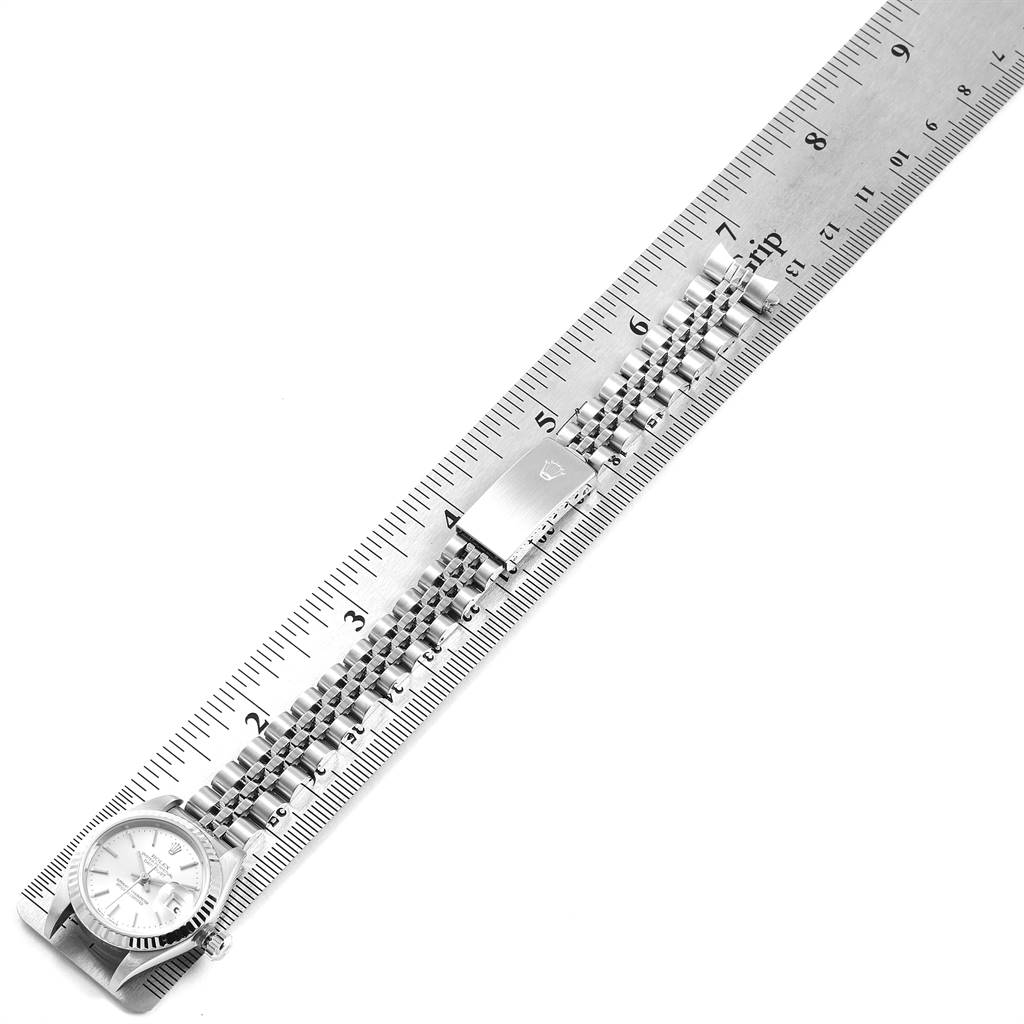 The image shows a top-down view of a Rolex Datejust 79174 Women's Stainless Steel Silver Dial 79174 Women's Stainless Steel Silver Dial watch alongside a measuring ruler, featuring the watch face and bracelet.