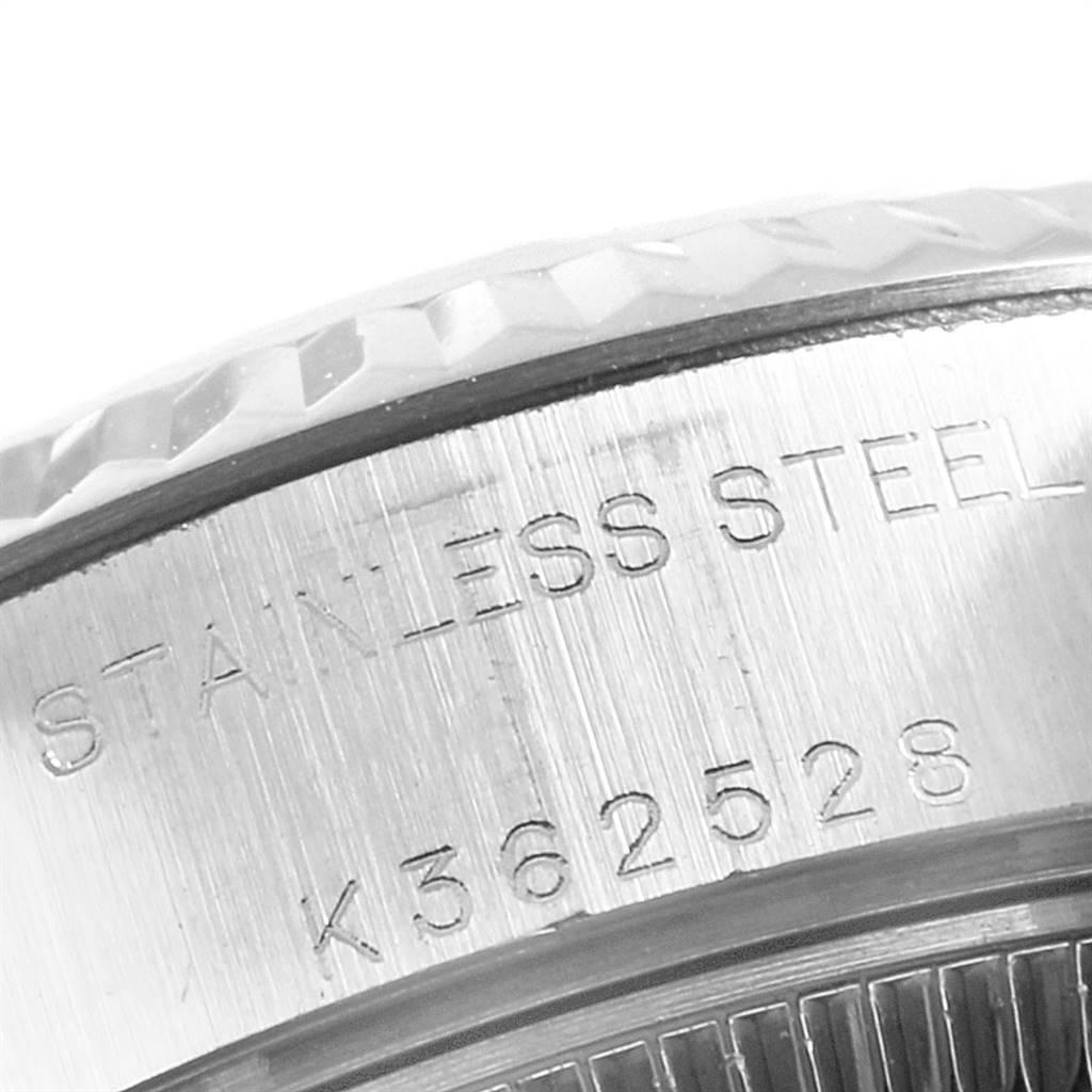 This image shows a close-up of the side engraving and fluted bezel of a Rolex Datejust 79174 Women's Stainless Steel Blue Dial 79174 Women's Stainless Steel Blue Dial watch.