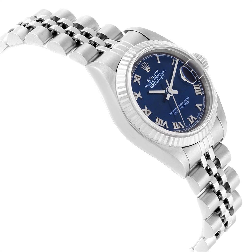 The Rolex Datejust 79174 Women's Stainless Steel Blue Dial 79174 Women's Stainless Steel Blue Dial watch is shown at a tilted angle highlighting its bracelet, fluted bezel, and blue dial with Roman numerals.