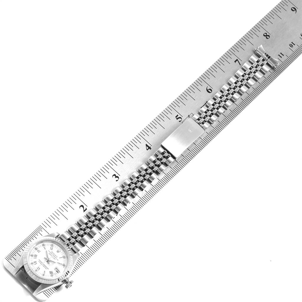 The image shows a Rolex Datejust 69174 Women's Stainless Steel White Dial 69174 Women's Stainless Steel White Dial watch placed next to a ruler, displaying the face and bracelet from a top-down angle.