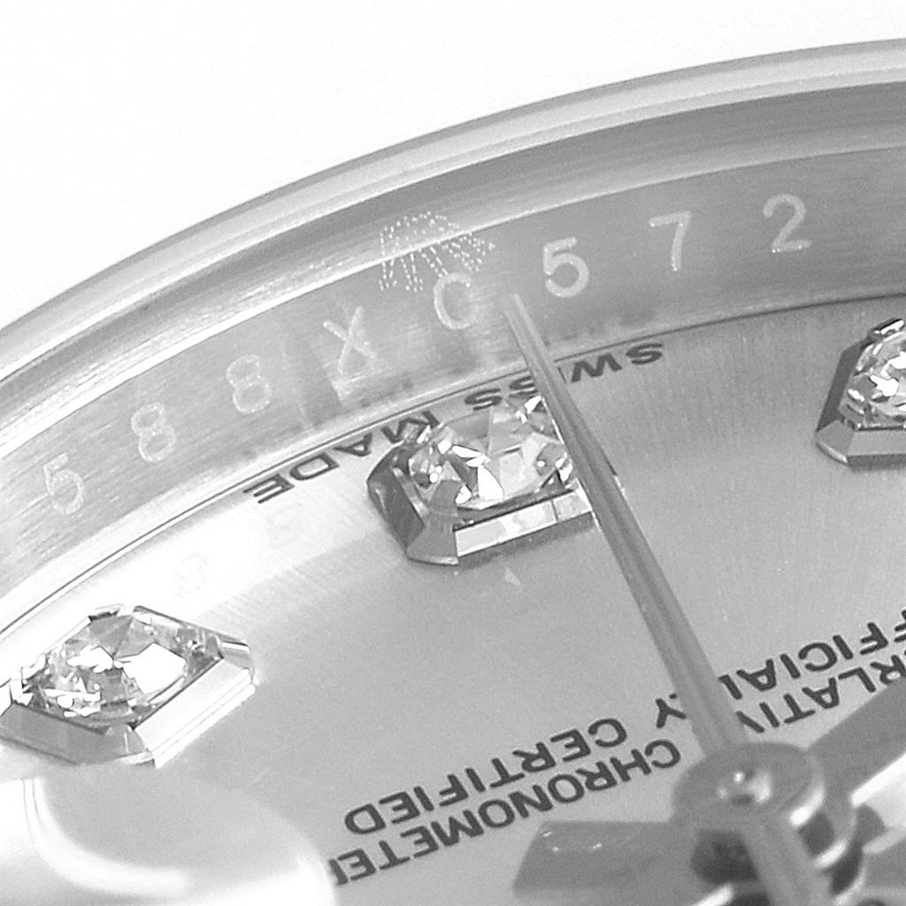 This close-up image of a Rolex Datejust 179174 Women's Stainless Steel Silver Dial 179174 Women's Stainless Steel Silver Dial watch showcases the dial, various diamonds, and engravings around the bezel.
