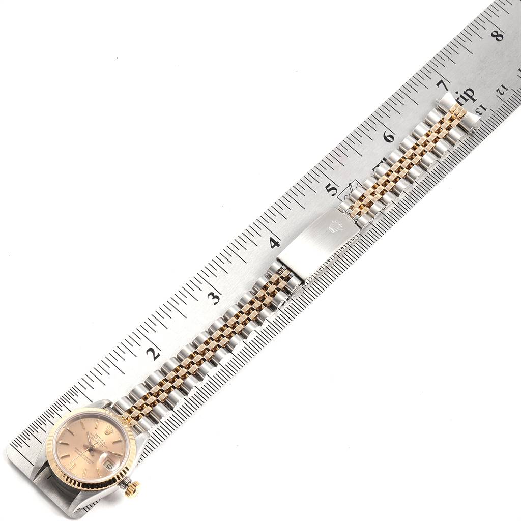 The Rolex Datejust 69173 Women's Stainless Steel Champagne Dial 69173 Women's Stainless Steel Champagne Dial watch is shown from above, featuring its face, bracelet, and clasp, measured against a ruler.