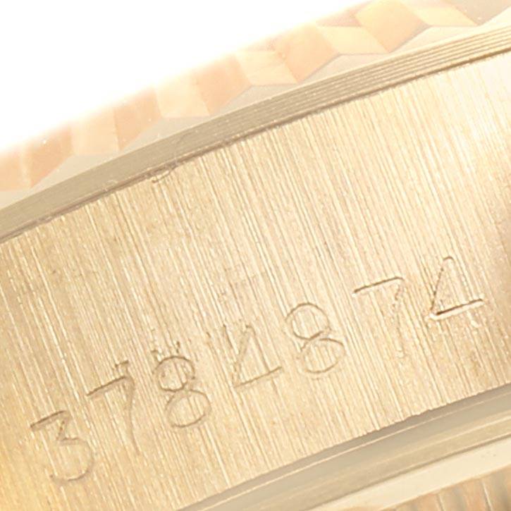This close-up image shows the engraved serial number and part of the fluted bezel of a Rolex Datejust 6917 Women
s Yellow Gold White Dial 6917 Women
s Yellow Gold White Dial watch.