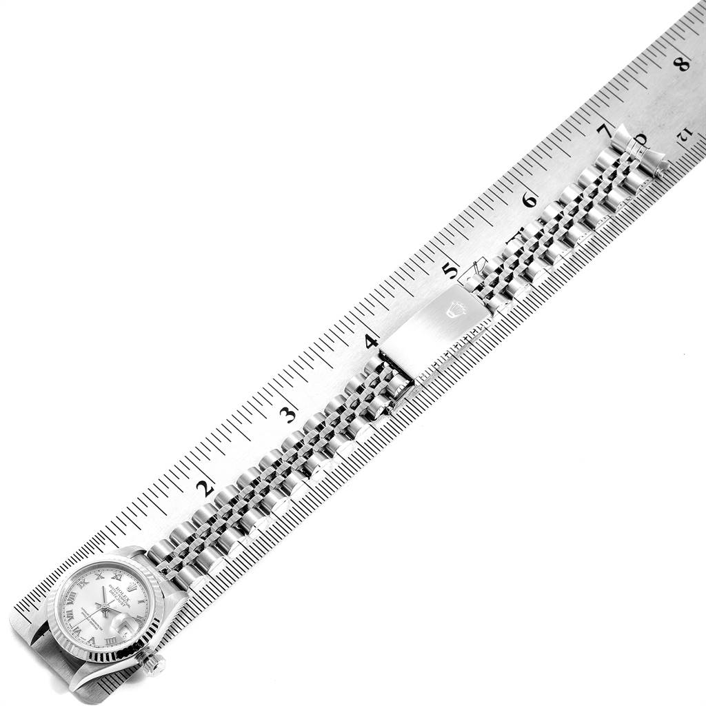 This image shows a Rolex Datejust 79174 Women's Stainless Steel Grey Dial 79174 Women's Stainless Steel Grey Dial watch laid flat next to a ruler, displaying its bracelet and face from an overhead angle.