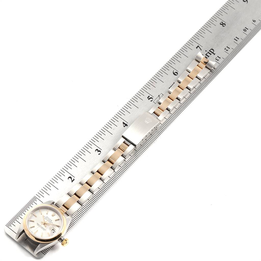 The image shows the face and bracelet of a Rolex Datejust 79163 Women's Steel and Gold (two tone) Silver Dial 79163 Women's Steel and Gold (two tone) Silver Dial watch, positioned next to a ruler for measurement.