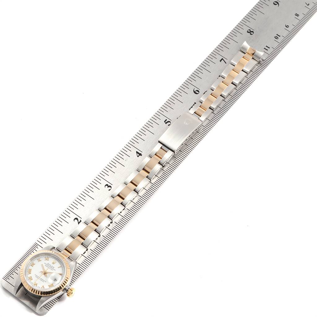 The image shows a Rolex Datejust 79173 Women's Steel and Gold (two tone) White Dial 79173 Women's Steel and Gold (two tone) White Dial watch and part of its strap laid along a ruler, viewed from a top-down angle.