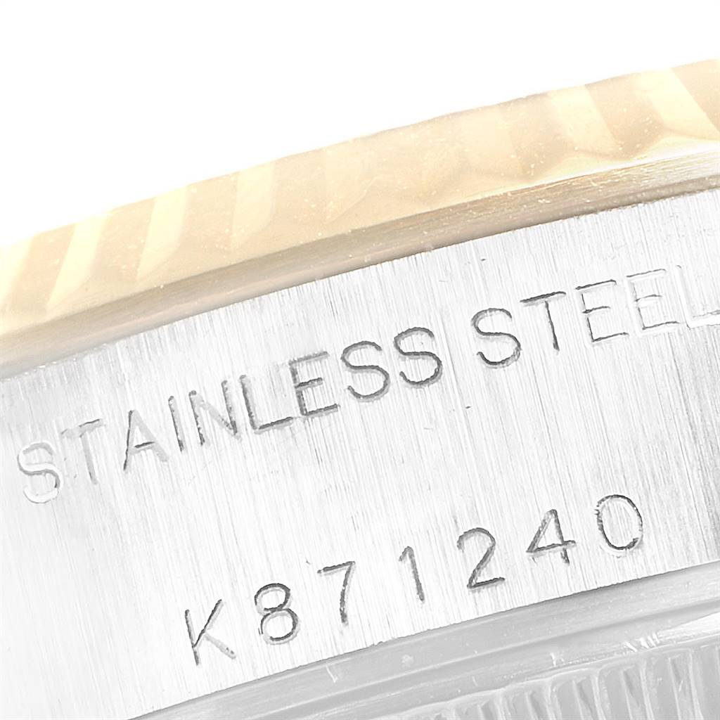 This image shows a close-up of the case side and part of the bezel of a Rolex Datejust 79173 Women's Steel and Gold (two tone) White Dial 79173 Women's Steel and Gold (two tone) White Dial watch, displaying its serial number and "stainless steel" marking.