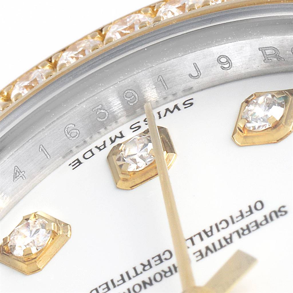 This close-up image of a Rolex Datejust 179383 Women's Steel and Gold (two tone) White Dial 179383 Women's Steel and Gold (two tone) White Dial watch showcases the bejeweled bezel, part of the dial, and gold-toned hour markers.