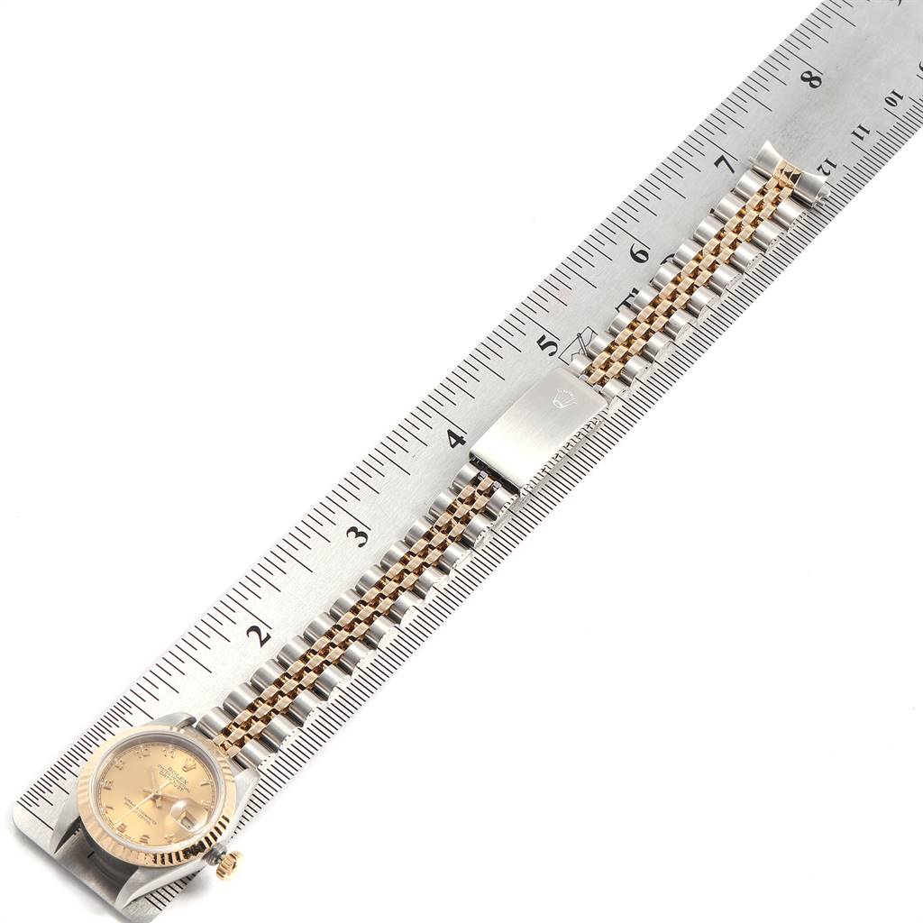The image shows a Rolex Datejust 69173 Women
s Stainless Steel Champagne Dial 69173 Women
s Stainless Steel Champagne Dial watch placed next to a ruler, highlighting the watch case, dial, and bracelet.