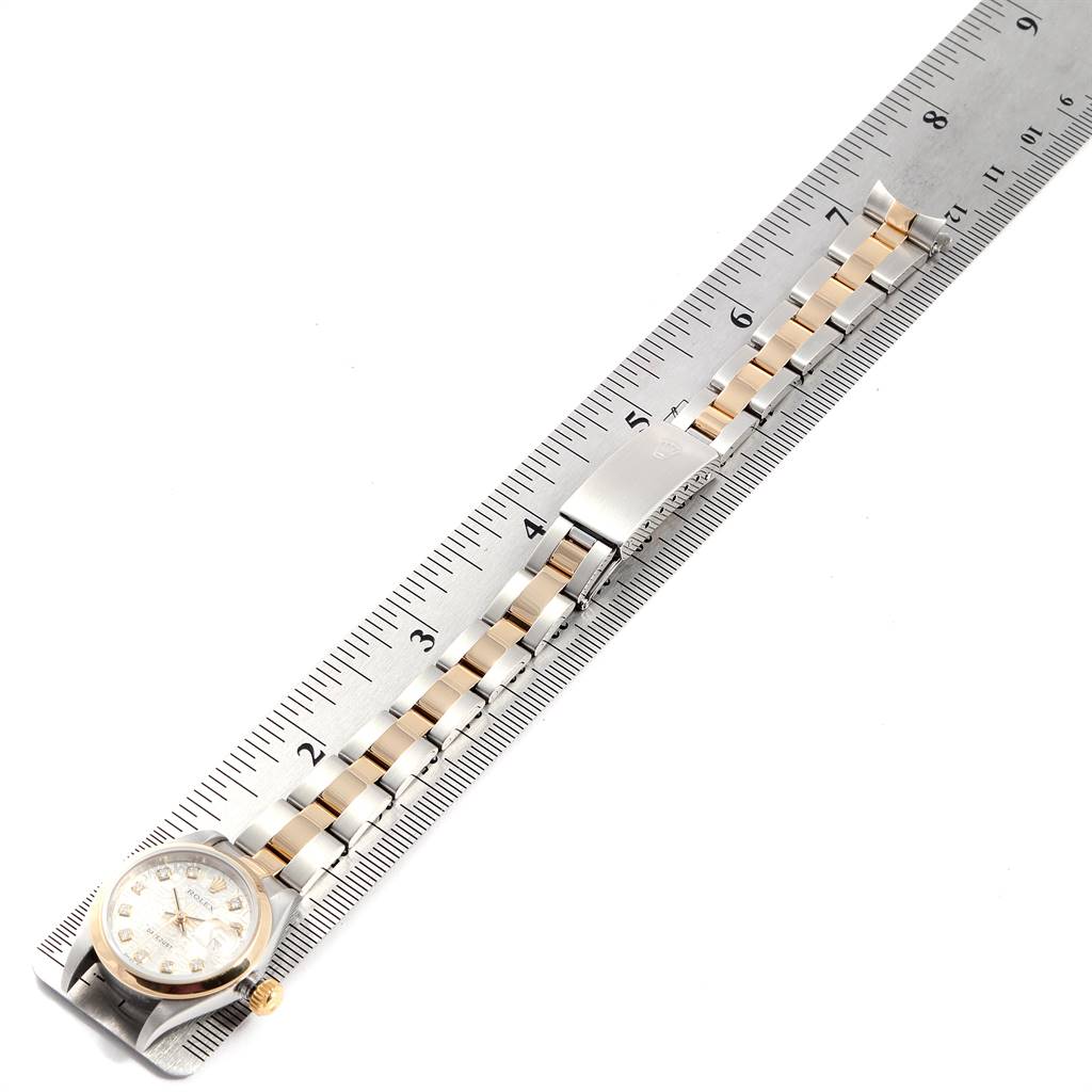 The Rolex Datejust 79163 Women's Steel and Gold (two tone) Silver Dial 79163 Women's Steel and Gold (two tone) Silver Dial watch is shown from an overhead angle, displaying the dial, bracelet, and clasp next to a ruler.