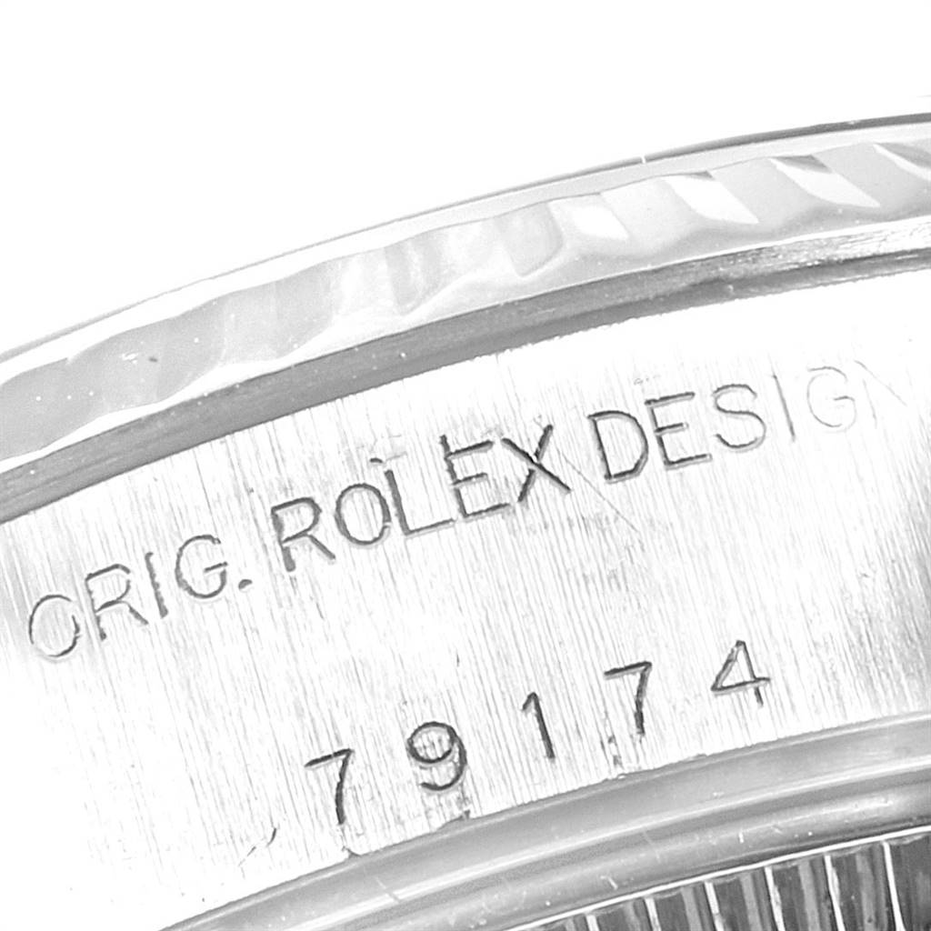 The image shows a close-up of the serial number and "ROLEX DESIGN" engraving on the case of a Rolex Datejust 79174 Women's Stainless Steel Pink Dial 79174 Women's Stainless Steel Pink Dial watch.