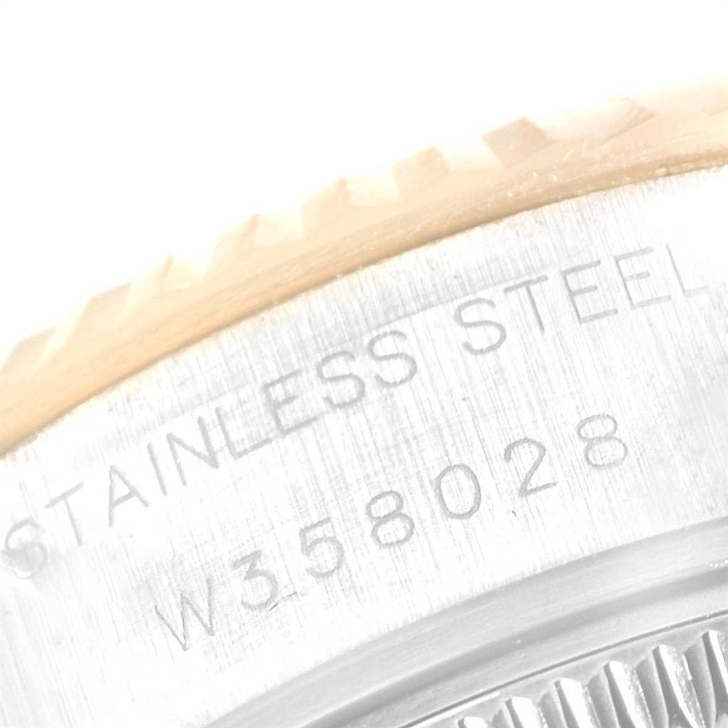This image shows a close-up of the case back and part of the bezel of a Rolex Datejust 69173 Women's Steel and Gold (two tone) White Dial 69173 Women's Steel and Gold (two tone) White Dial watch, highlighting serial numbers and "stainless steel" engraving.