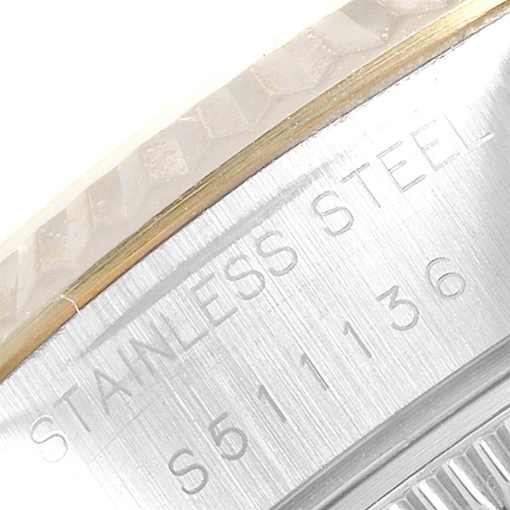 This image shows a close-up of the stainless steel side of a Rolex Datejust 69173 Women's Steel and Gold (two tone) Champagne Dial 69173 Women's Steel and Gold (two tone) Champagne Dial watch, including part of the bezel and engraving.