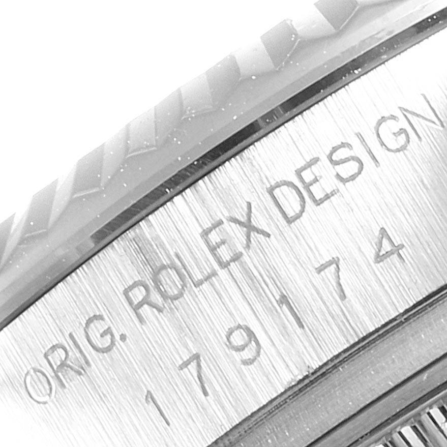 The image shows a close-up view of the bezel and case side of a Rolex Datejust 179174 Women's Stainless Steel Blue Dial 179174 Women's Stainless Steel Blue Dial watch, featuring engraved text and part numbers.