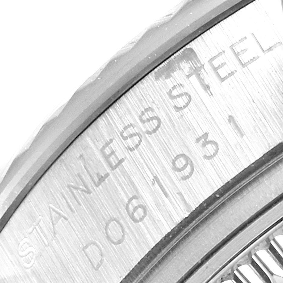 The image shows a close-up of the side of a Rolex Datejust 179174 Women's Stainless Steel Blue Dial 179174 Women's Stainless Steel Blue Dial watch with part of the bezel and engraved text on the caseback.