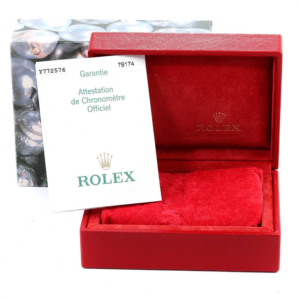 The image shows a Rolex Datejust 79174 Women
s Stainless Steel Black Dial 79174 Women
s Stainless Steel Black Dial watch box with a red interior and a warranty card.
