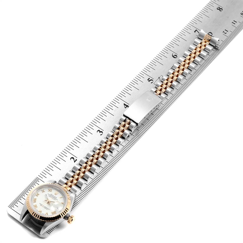 The Rolex Datejust 69173 Women's Stainless Steel White Dial 69173 Women's Stainless Steel White Dial watch is shown from a top-down angle, displaying the face, bezel, and full bracelet laid on a ruler.