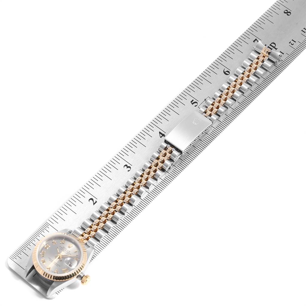 The image shows a Rolex Datejust 69173 Women
s Stainless Steel Silver Dial 69173 Women
s Stainless Steel Silver Dial watch with its bracelet placed on a ruler, highlighting its length and design details.