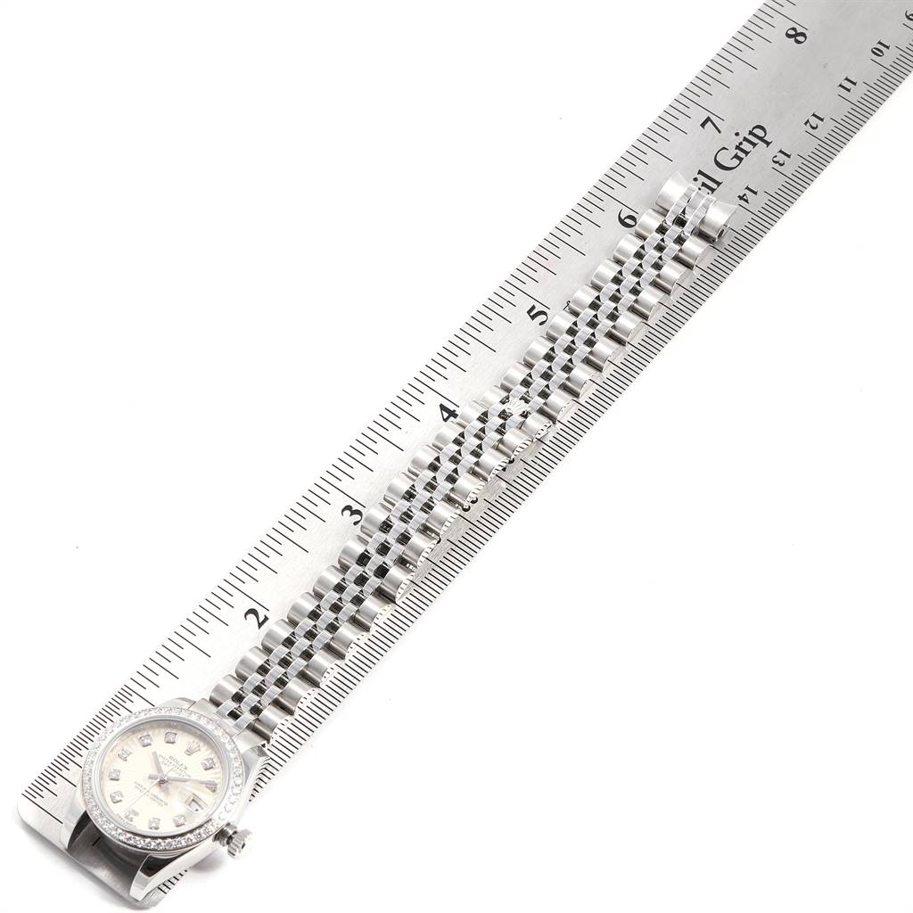The image shows a Rolex Datejust 179384 Women's Stainless Steel Silver Dial 179384 Women's Stainless Steel Silver Dial watch laid out beside a metal ruler, highlighting its face and band.