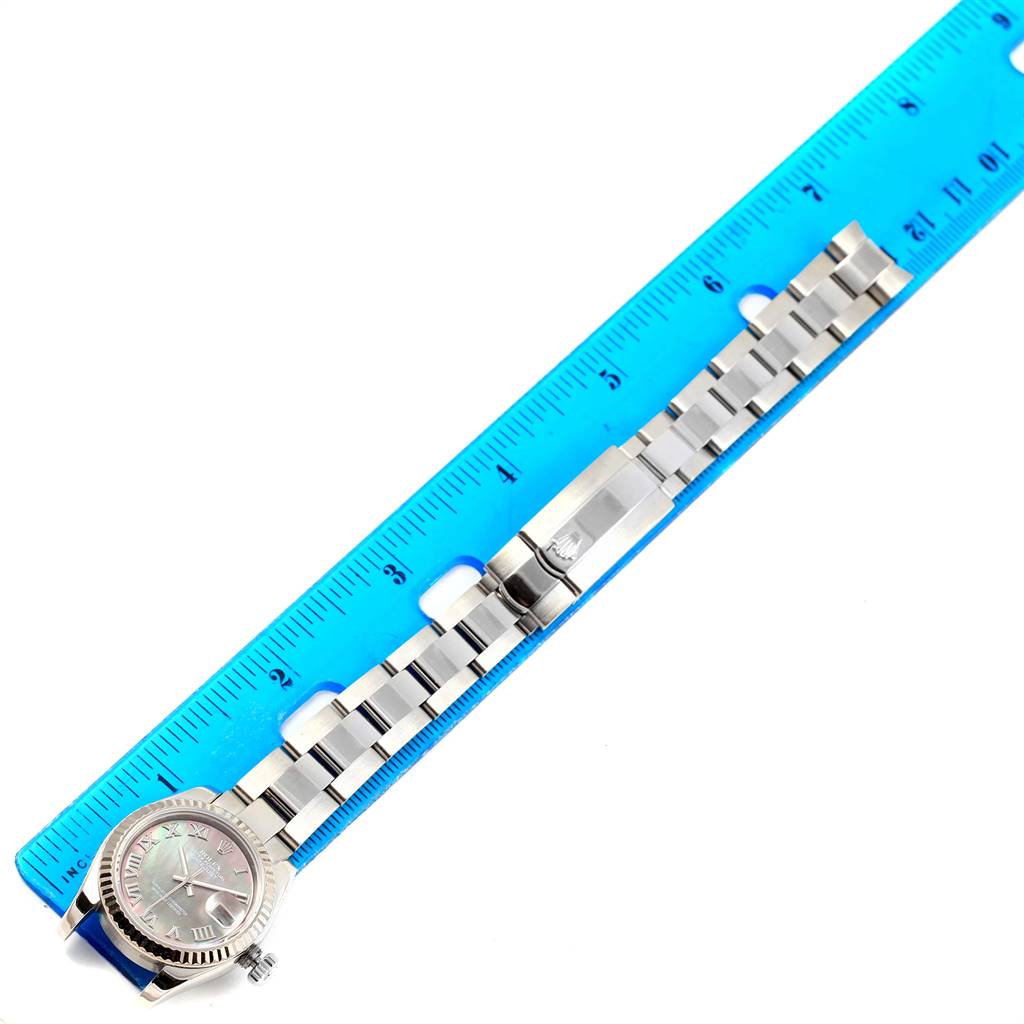 The image shows a Rolex Datejust 179174 Women's Stainless Steel Black Dial 179174 Women's Stainless Steel Black Dial watch laid flat next to a blue ruler, displaying the face, bezel, and bracelet.