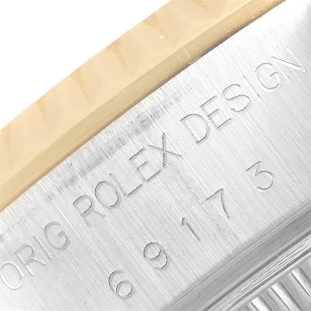 This close-up image shows the engraved serial number and branding on the metal case edge of a Rolex Datejust 69173 Women's Steel and Gold (two tone) Champagne Dial 69173 Women's Steel and Gold (two tone) Champagne Dial watch.