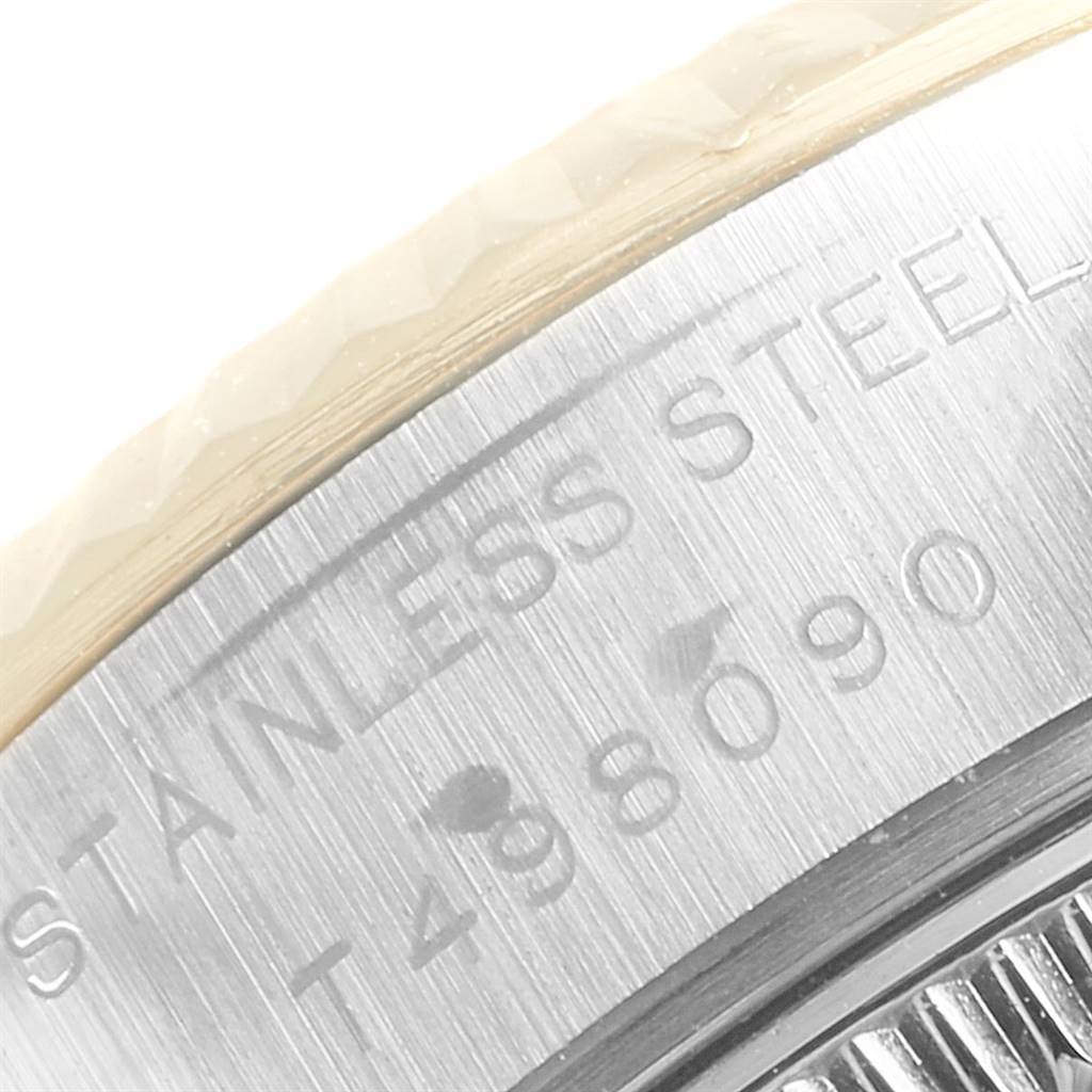This close-up image of the Rolex Datejust 69173 Women's Stainless Steel Silver Dial 69173 Women's Stainless Steel Silver Dial model shows part of the bezel and engraved text on the stainless steel case.