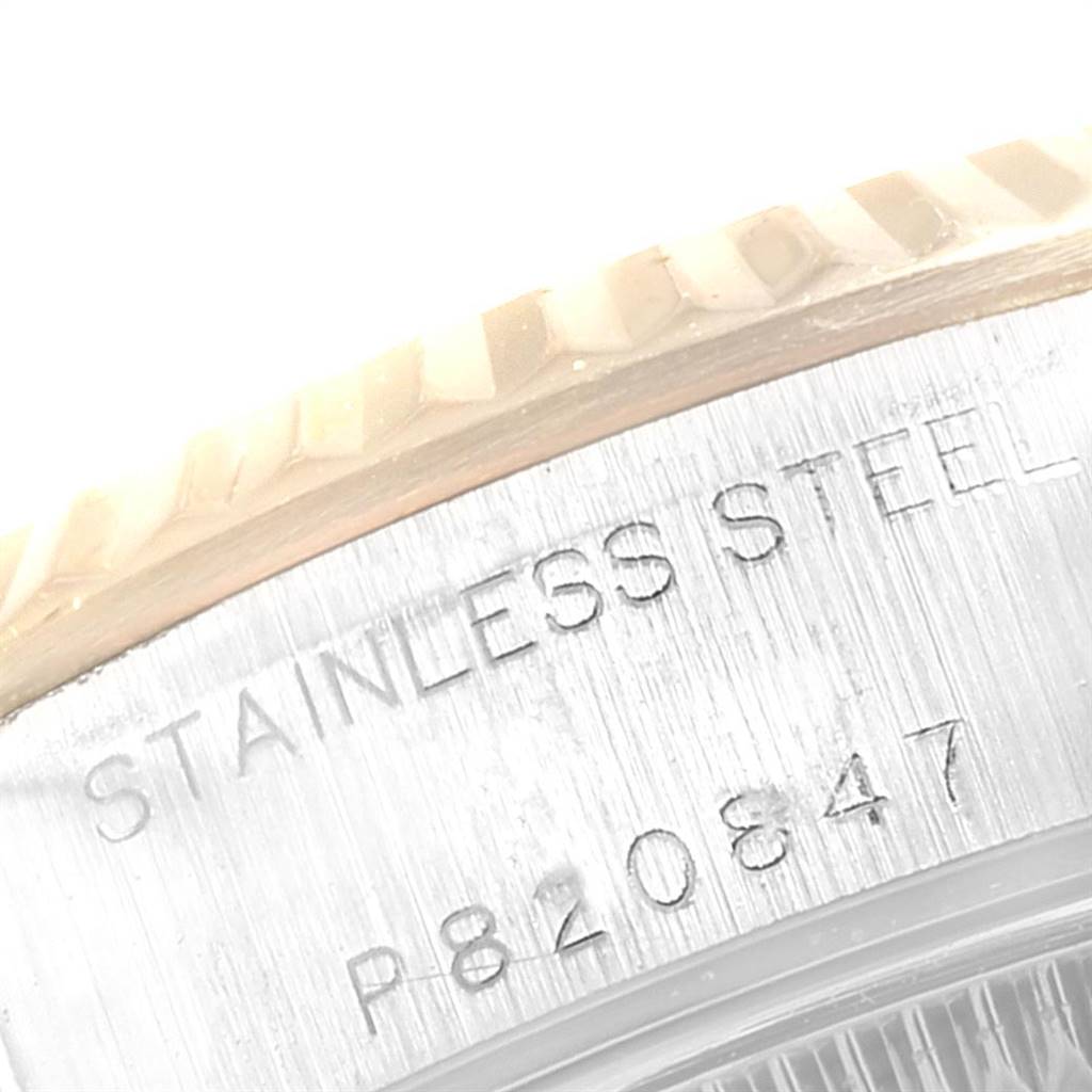 The image shows a close-up of the engraved serial numbers and the "STAINLESS STEEL" marking on the case of a Rolex Datejust 79173 Women's Steel and Gold (two tone) Mother of Pearl Dial 79173 Women's Steel and Gold (two tone) Mother of Pearl Dial watch.