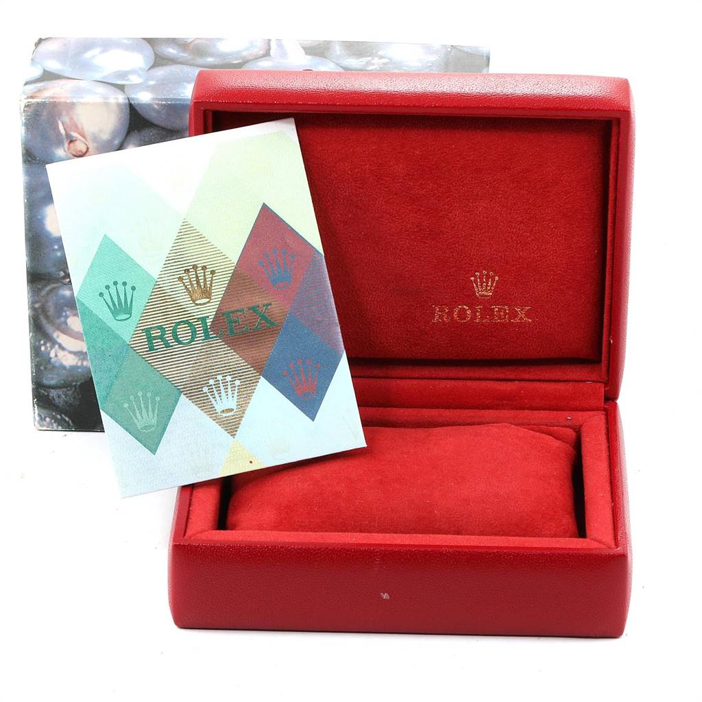 The image shows a red Rolex watch box and a branded booklet, with the watch itself not depicted.