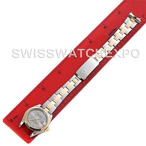 This image shows a Rolex Datejust 79163 Women's Steel and Gold (two tone) Silver Dial 79163 Women's Steel and Gold (two tone) Silver Dial watch, displayed fully extended alongside a red ruler, showcasing the face, case, and bracelet.