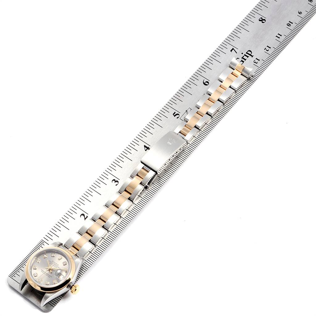 The Rolex Datejust 69163 Women's Steel and Gold (two tone) Grey Dial 69163 Women's Steel and Gold (two tone) Grey Dial watch is shown from overhead with the face and full length of the stainless steel and gold band placed against a ruler.