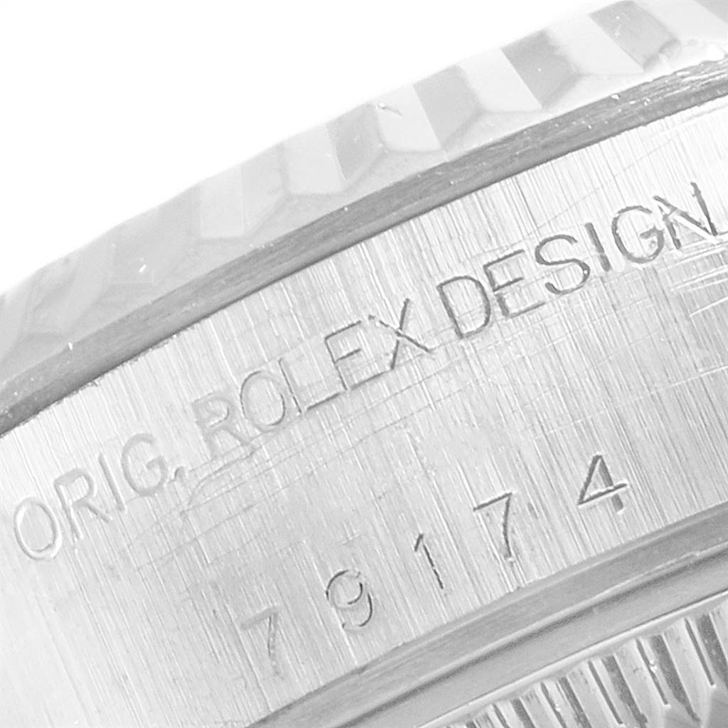 This close-up image shows the engraved side of a Rolex Datejust 79174 Women
s Stainless Steel Mother of Pearl Dial 79174 Women
s Stainless Steel Mother of Pearl Dial watch case with the text "ORIG. ROLEX DESIGN" and model number.