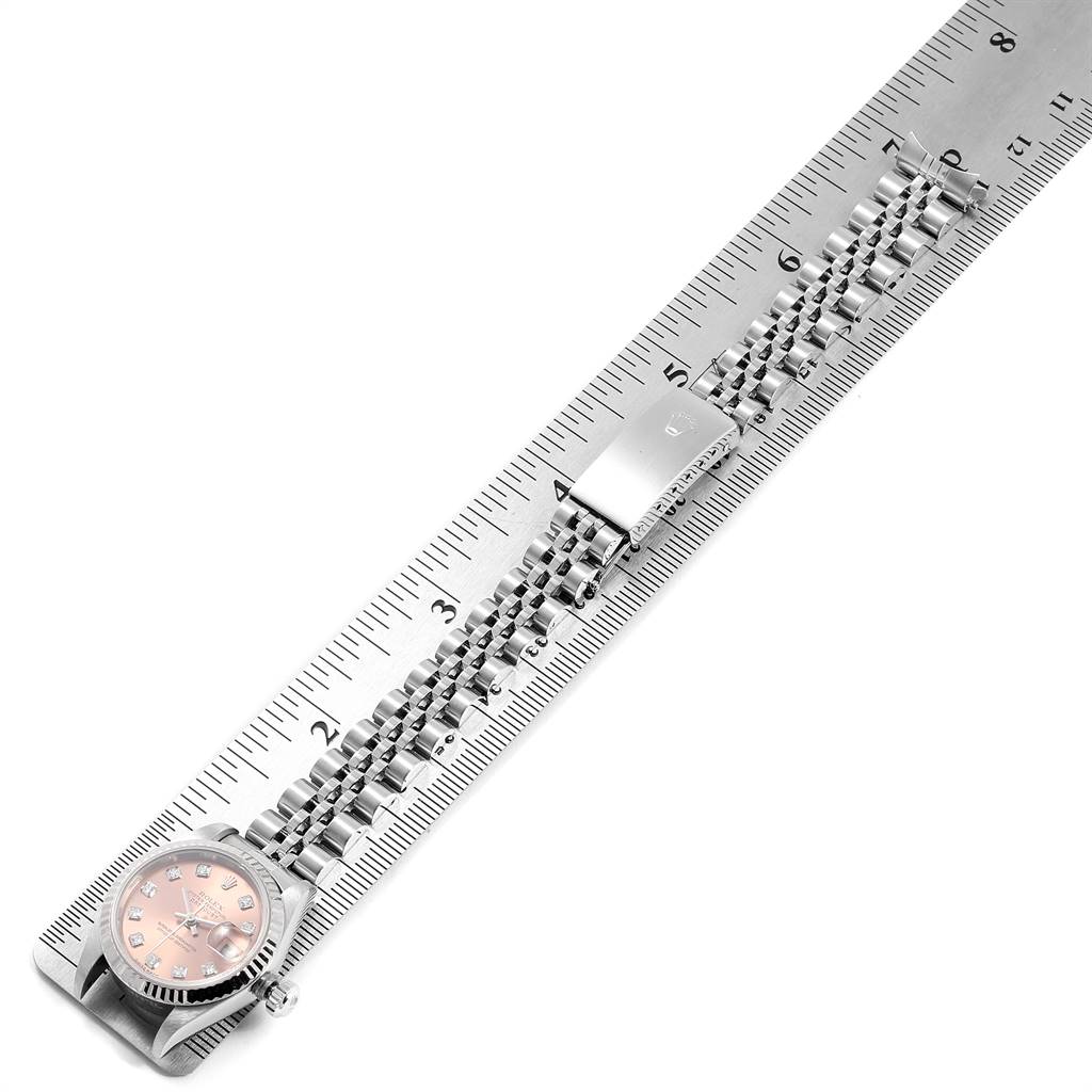 The Rolex Datejust 79174 Women
s Stainless Steel Pink Dial 79174 Women
s Stainless Steel Pink Dial watch is shown from a top-down angle, displaying the face and bracelet alongside a ruler for measurement.