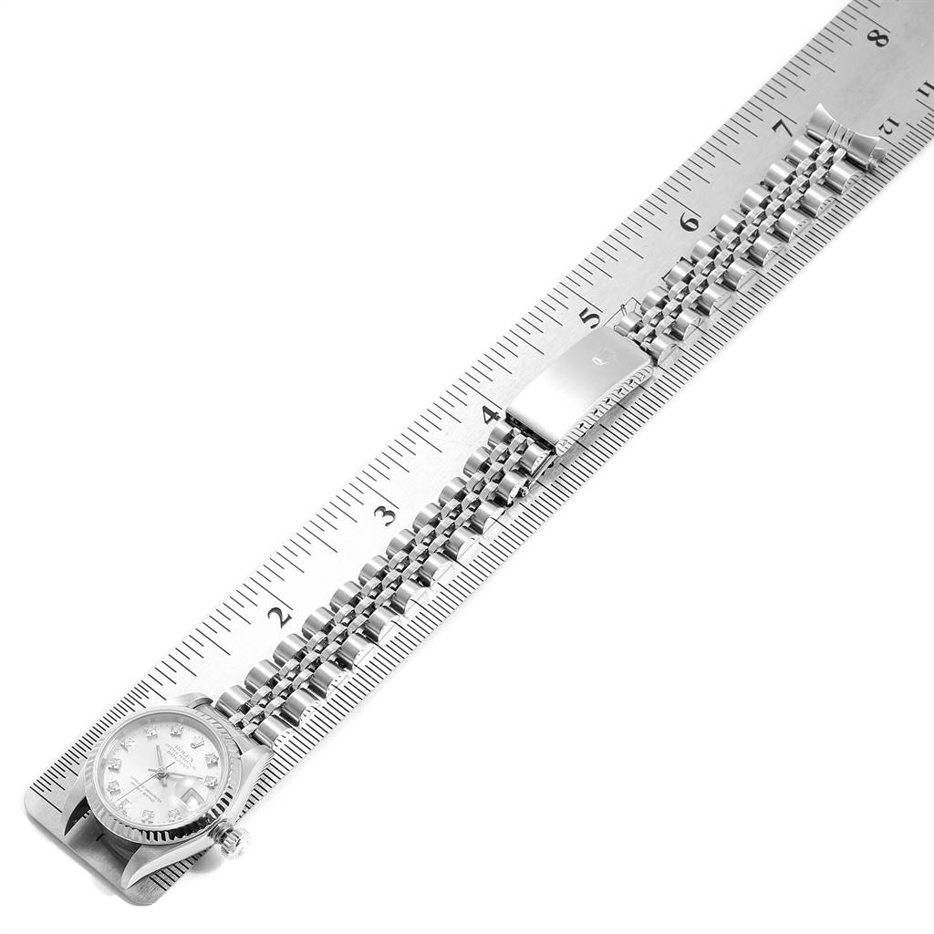 This image shows a Rolex Datejust 69174 Women
s Stainless Steel Silver Dial 69174 Women
s Stainless Steel Silver Dial watch measured against a ruler, highlighting the watch face and bracelet in an overhead view.